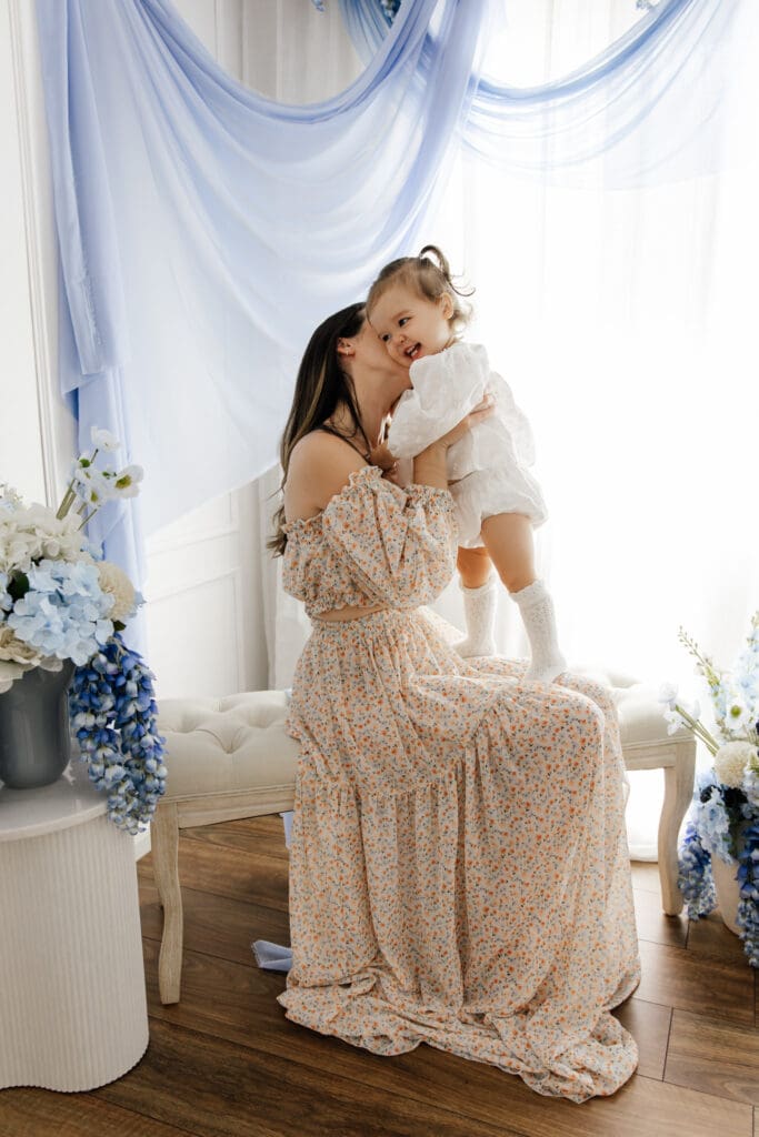 Mother kissing her toddler during Mère en Bleu Mother’s Day minis Sydney studio session with soft blue styling