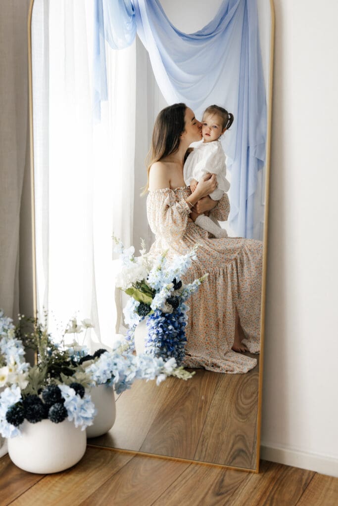 Mother holding her baby reflected in a mirror during Mother’s Day minis Sydney studio session