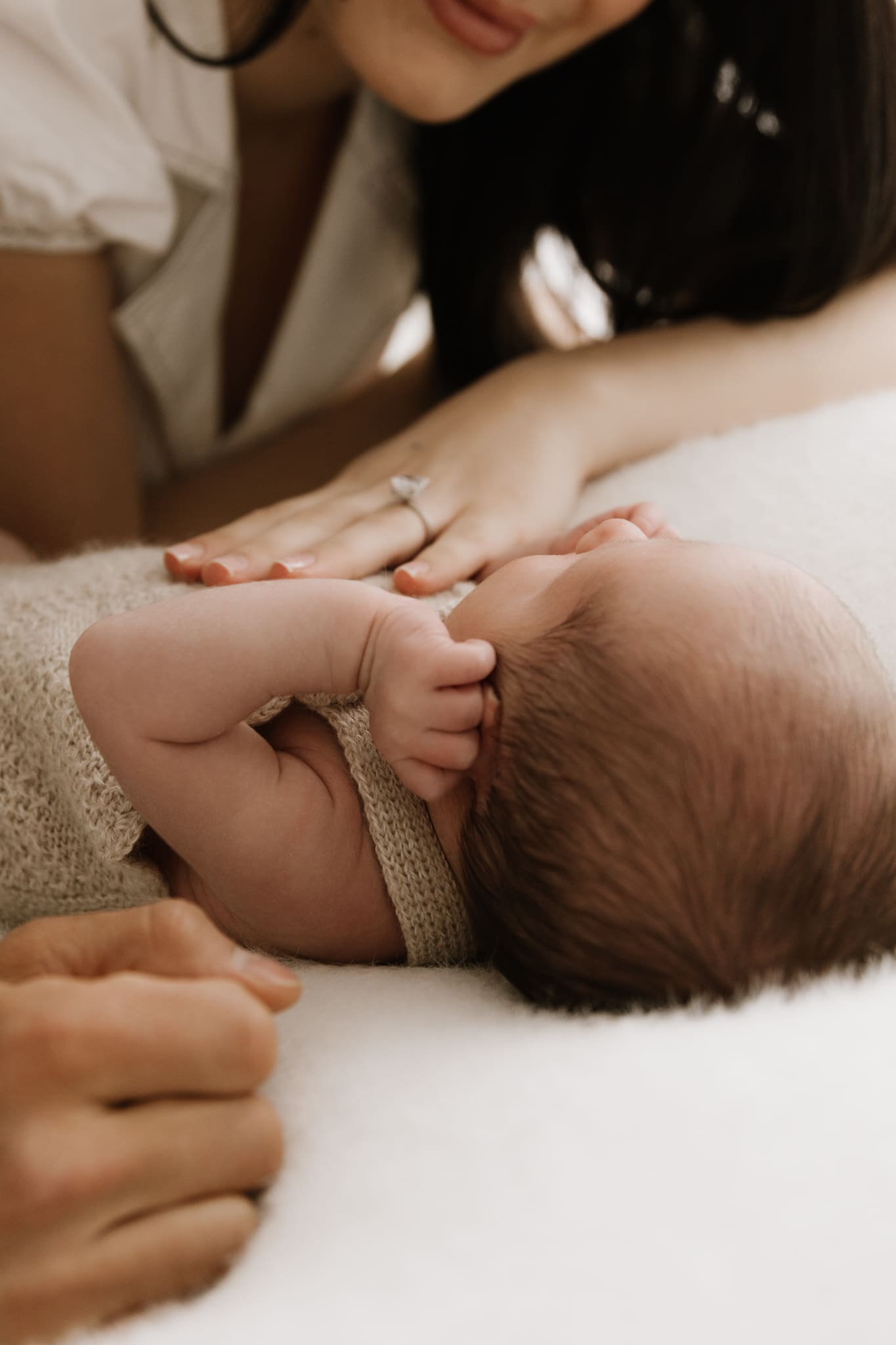 mother gently touching newborn during Sydney studio photography session